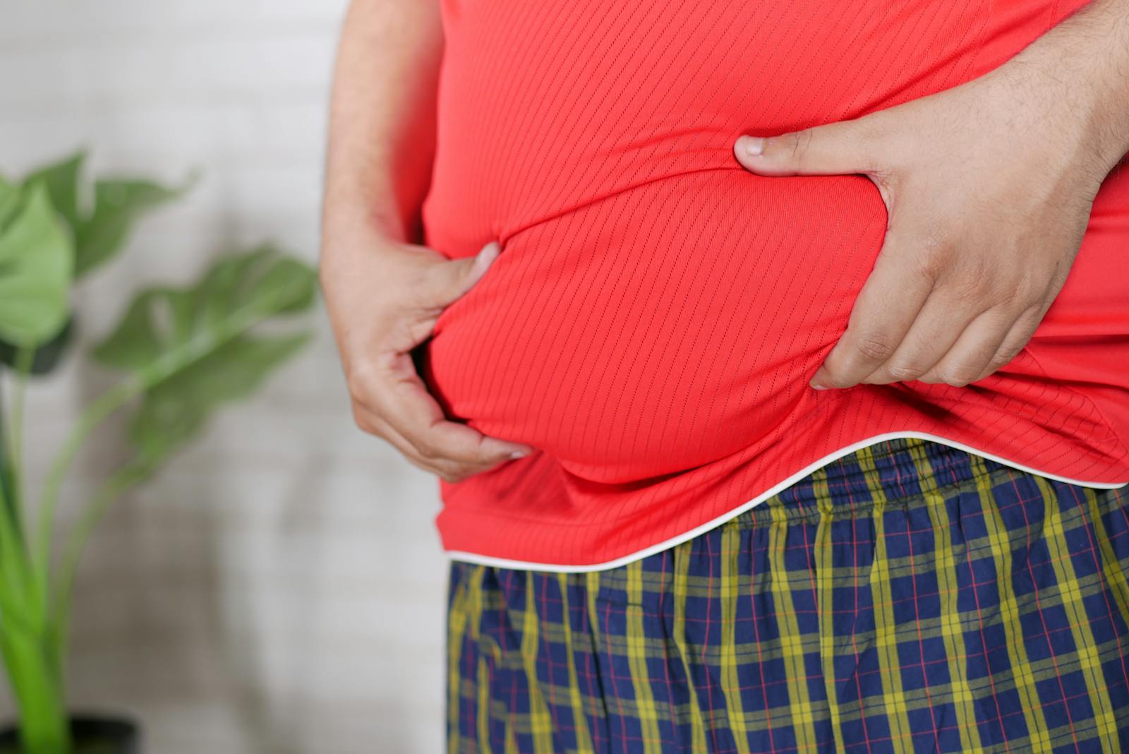 Hands Grasping Belly Fat through Shirt