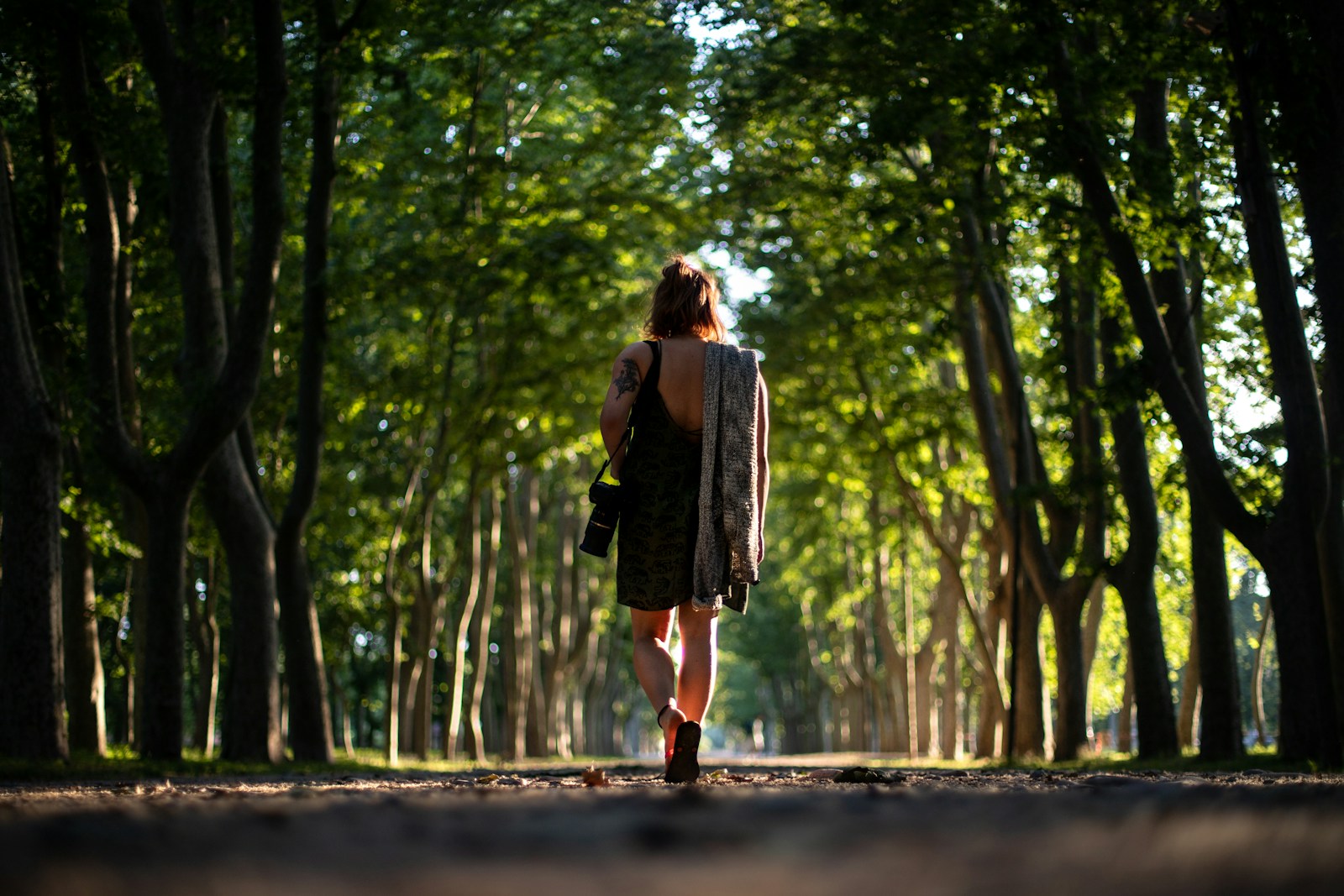 woman in black dress carrying camera