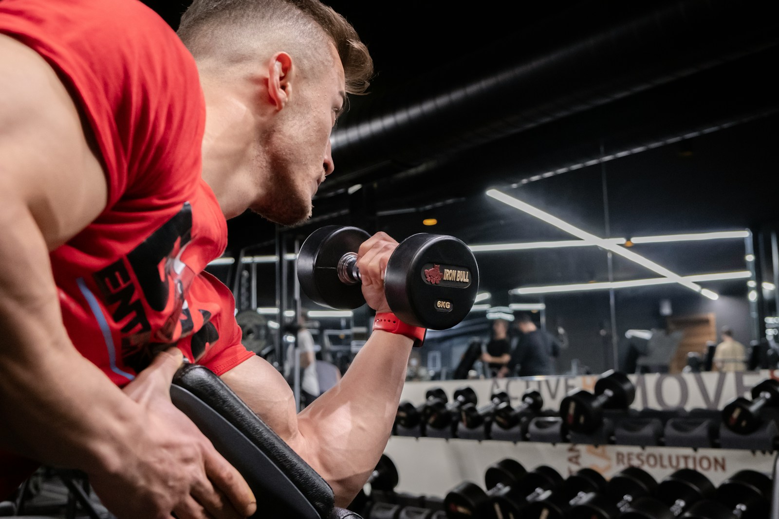 a man lifting a dumbbell in a gym